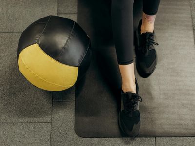 Person stretching legs on a black mat